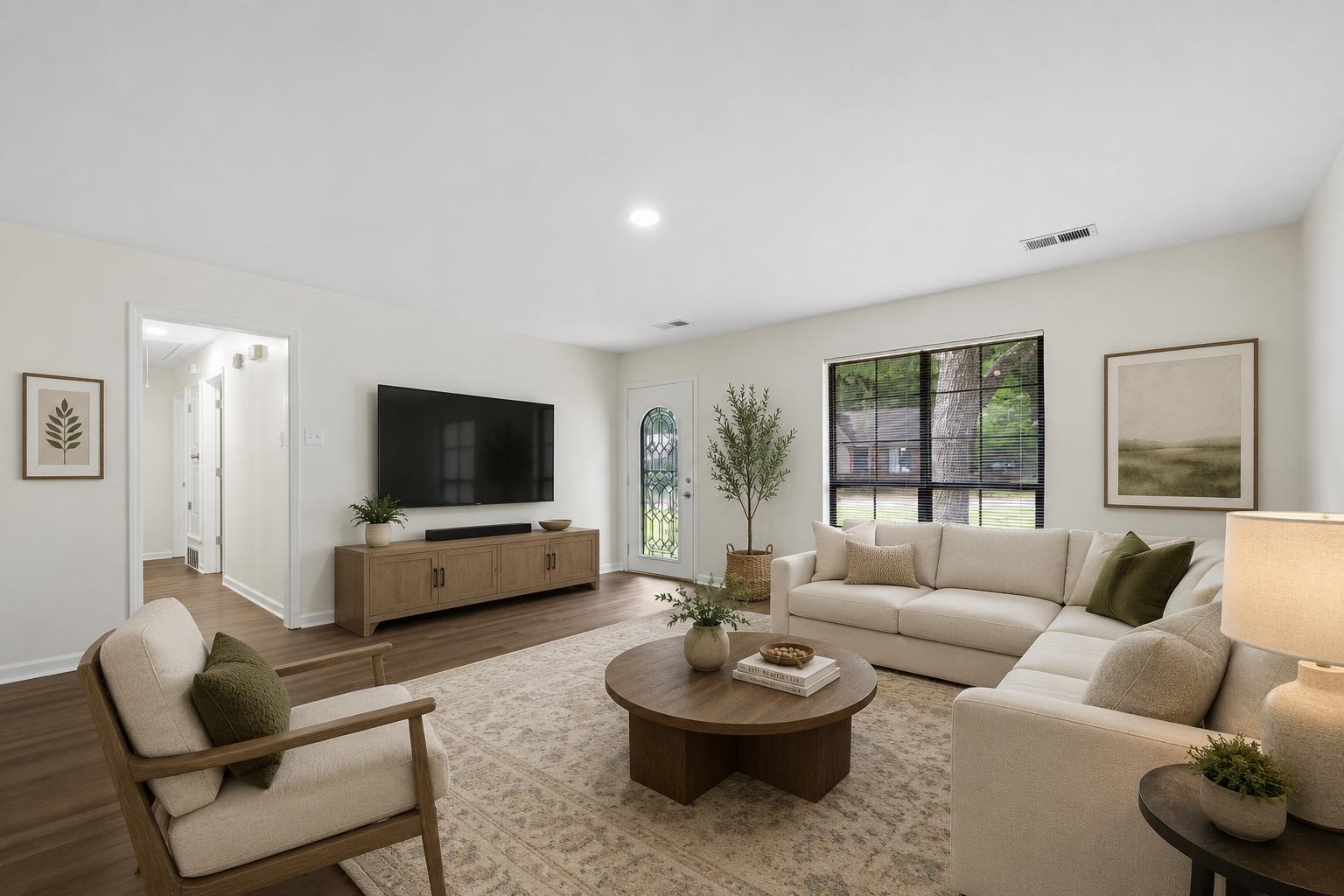 6400 Saginaw Road Memphis, TN 38134 - Photo 2 of 27 Spacious great room with updated wood laminate flooring, smooth ceilings, fresh paint, and large windows that fill the space with natural light. This photo has been virtually staged.
