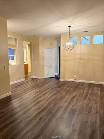 an empty room with wooden floor and window