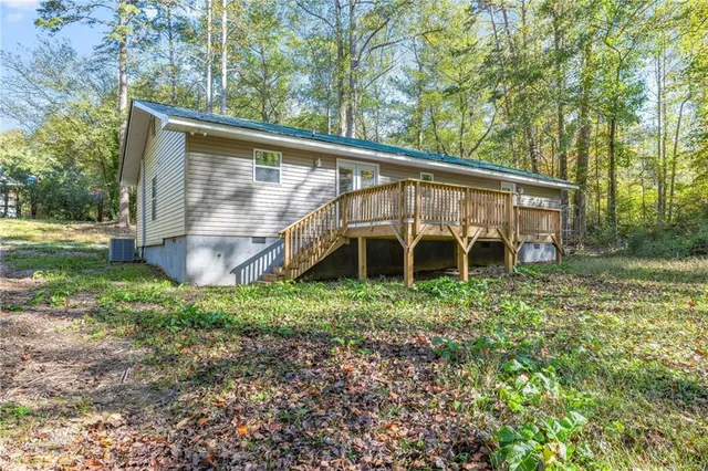 a backyard of a house with wooden deck and outdoor seating