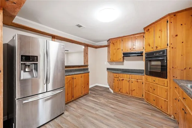 a kitchen with stainless steel appliances a refrigerator and wooden cabinets