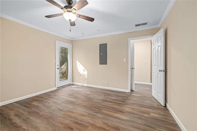 a view of an empty room with window and wooden floor