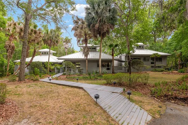 a front view of a house with a yard and trees