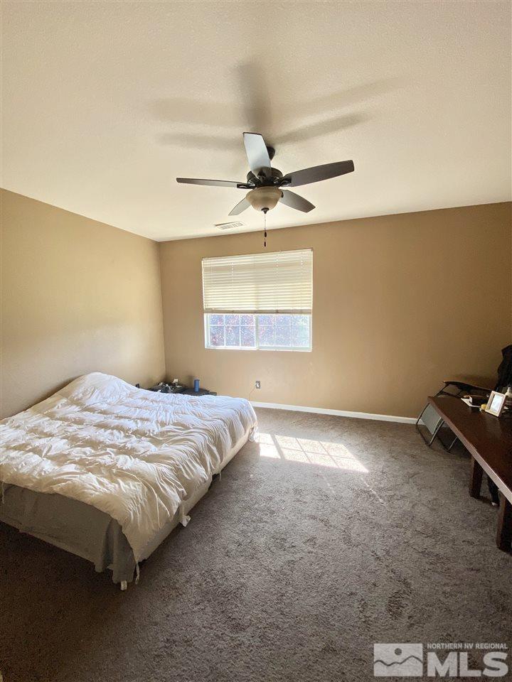 11034 Colton Drive Reno, NV 89521 - Photo 8 of 13 a bed sitting in a bedroom next to a window
