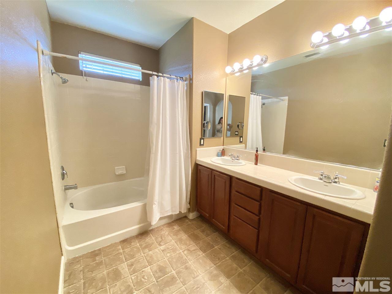 11034 Colton Drive Reno, NV 89521 - Photo 9 of 13 a bathroom with a double vanity sink mirror and shower