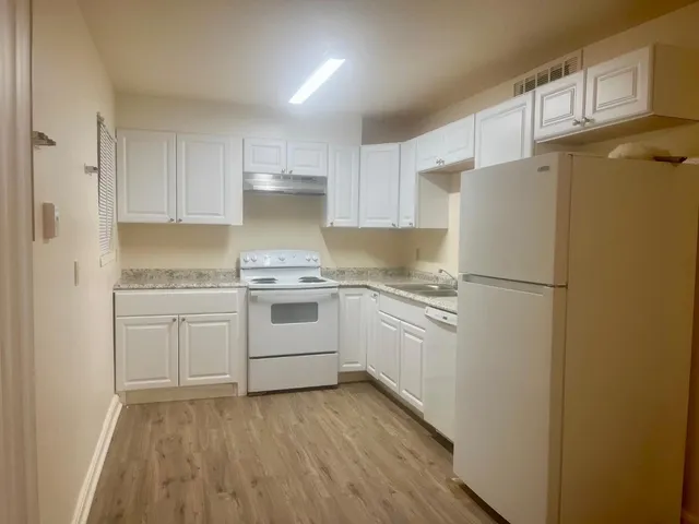 a kitchen with white cabinets and white stainless steel appliances