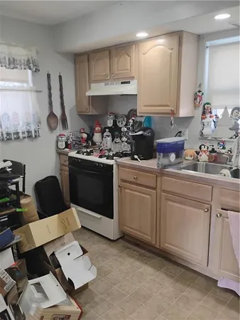 a kitchen with a sink dishwasher stove and white cabinets