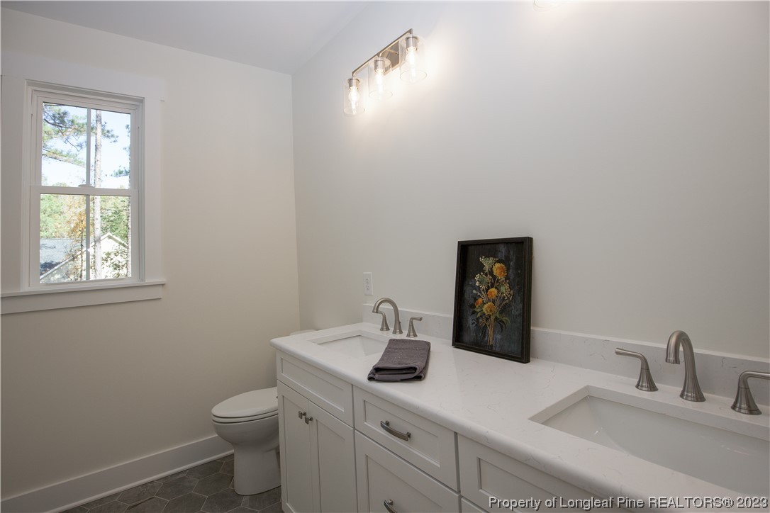1365 McCaskill Road Carthage, NC 28327 - Photo 25 of 50 a bathroom with a toilet sink vanity and window
