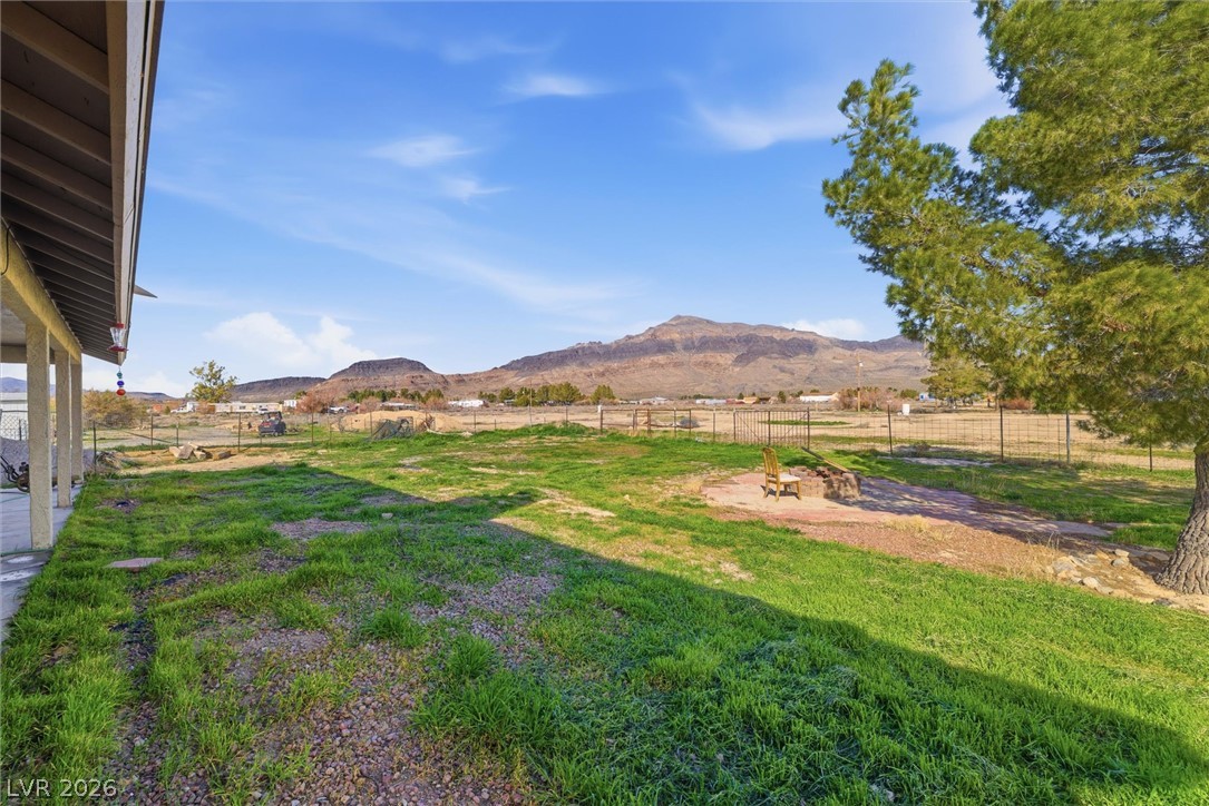 2780 West Simkins Road Pahrump, NV 89060 - Photo 34 of 40 A spacious yard offers tranquil views of distant mountains under a vast, clear sky.