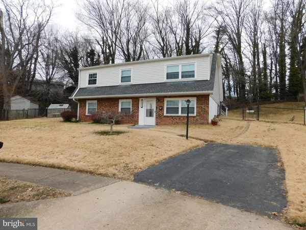 a front view of a house with a yard covered with snow