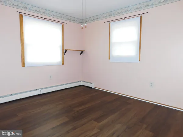 a view of a room that has wooden floor and a window