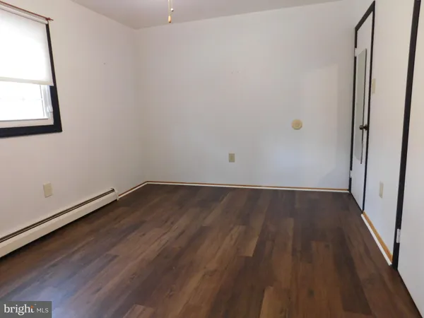 a view of a room with wooden floor and a window