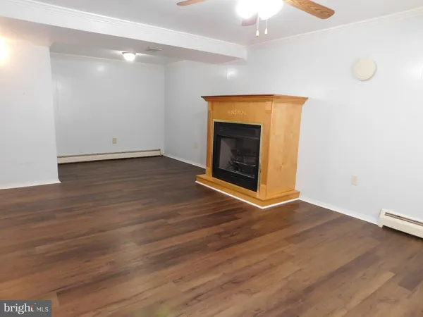 an empty room with wooden floor and fireplace