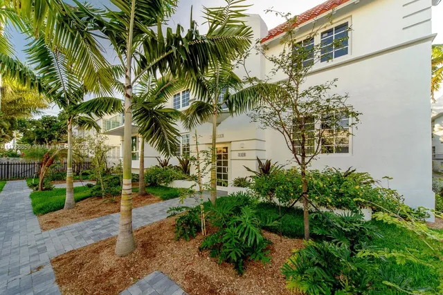a view of a palm trees front of house