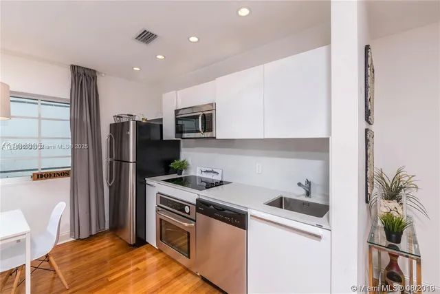 a kitchen with a sink a refrigerator and a stove top oven