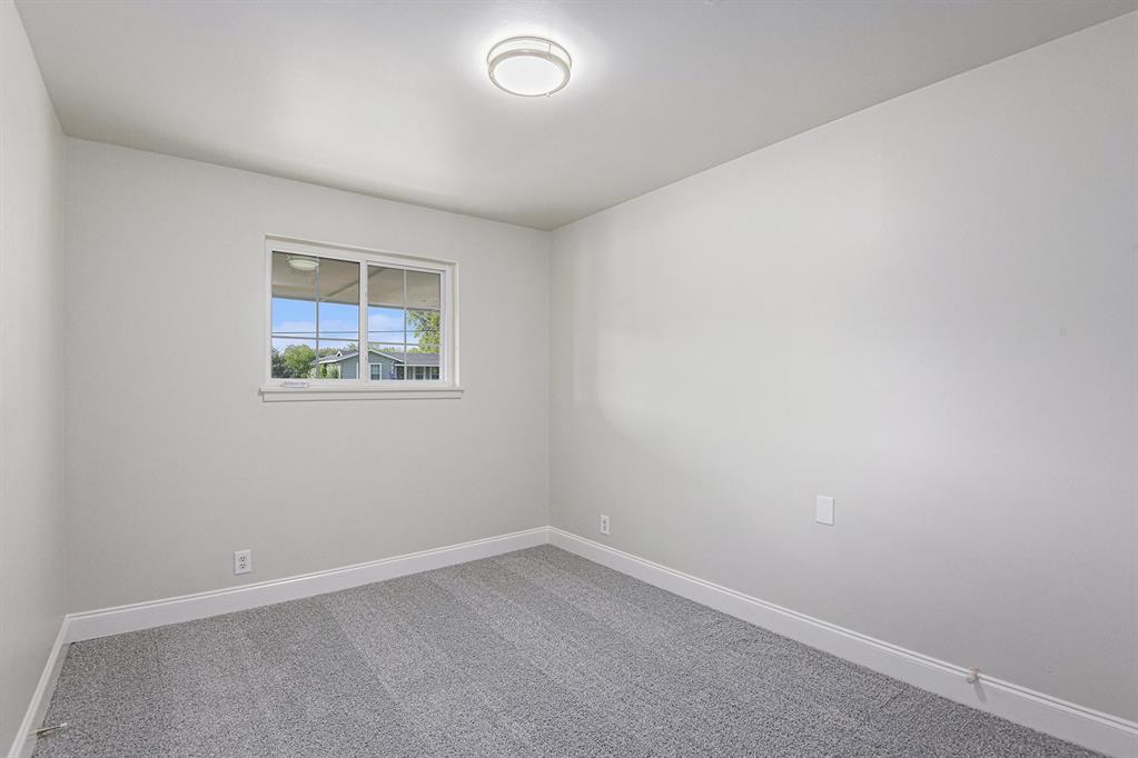 233 Victoria Avenue Azle, TX 76020 - Photo 11 of 25 Empty room featuring carpet floors and baseboards