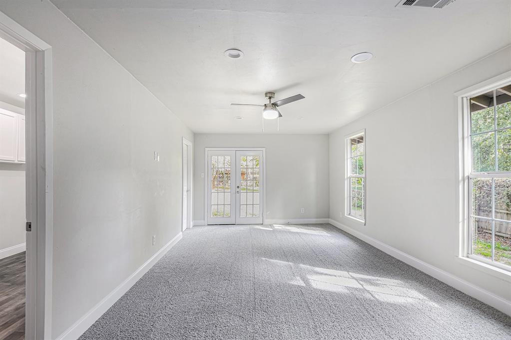 233 Victoria Avenue Azle, TX 76020 - Photo 19 of 25 Empty room with carpet flooring, plenty of natural light, french doors, and a ceiling fan