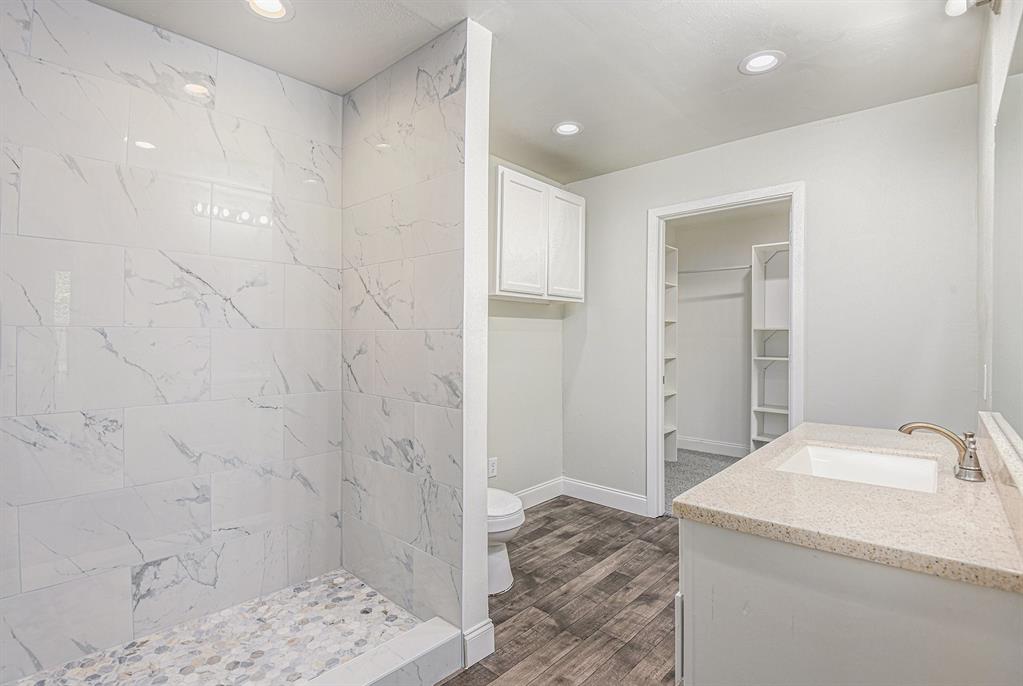 233 Victoria Avenue Azle, TX 76020 - Photo 21 of 25 Full bath with vanity, dark wood-style flooring, a stall shower, recessed lighting, and a spacious closet