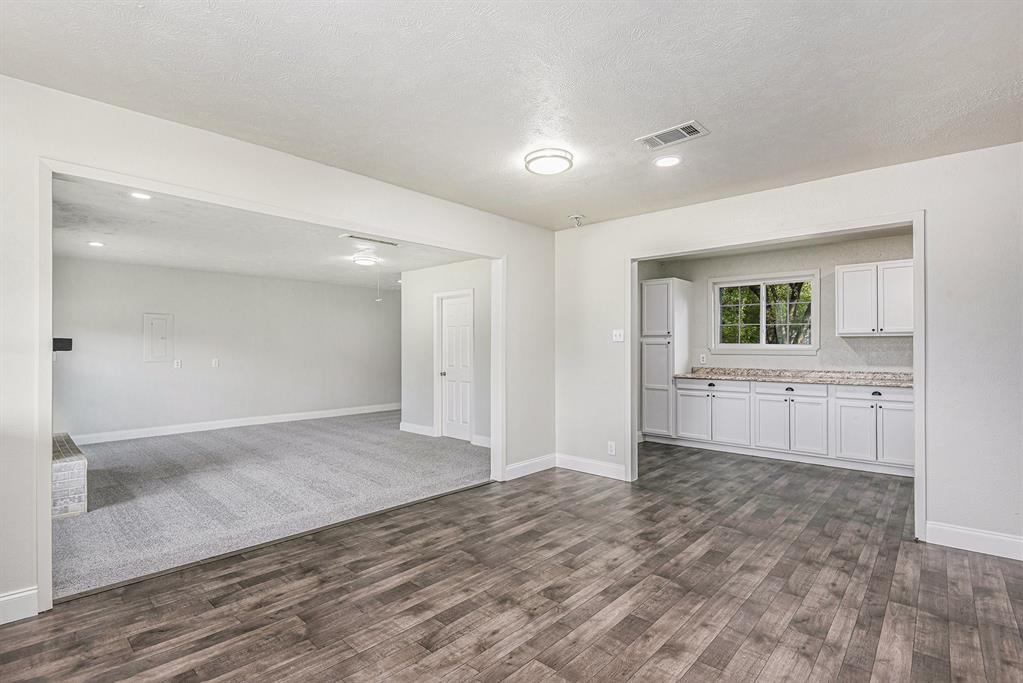 233 Victoria Avenue Azle, TX 76020 - Photo 7 of 25 Unfurnished living room featuring a textured ceiling, dark wood finished floors, and recessed lighting