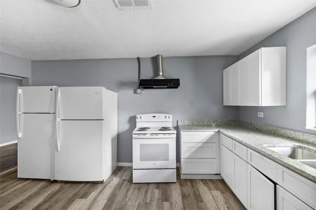 a kitchen with a refrigerator stove and white cabinets