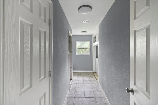 a view of a hallway with wooden floor and closet area