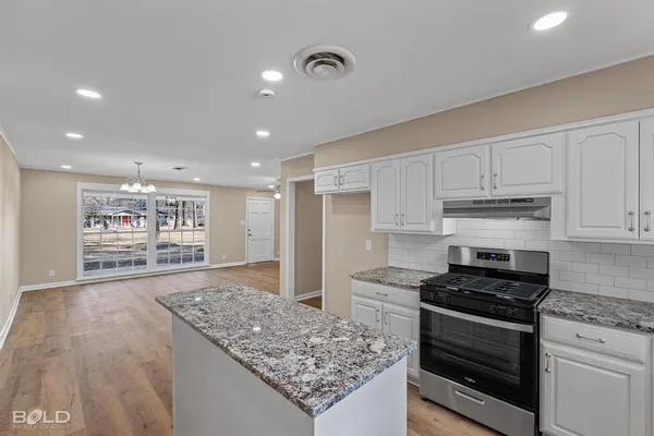 a kitchen with stainless steel appliances granite countertop a stove and a refrigerator