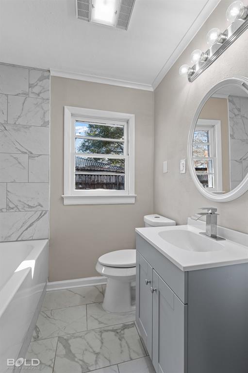1211 Lee Street Benton, LA 71006 - Photo 22 of 39 a bathroom with a granite countertop toilet a sink a mirror and a window