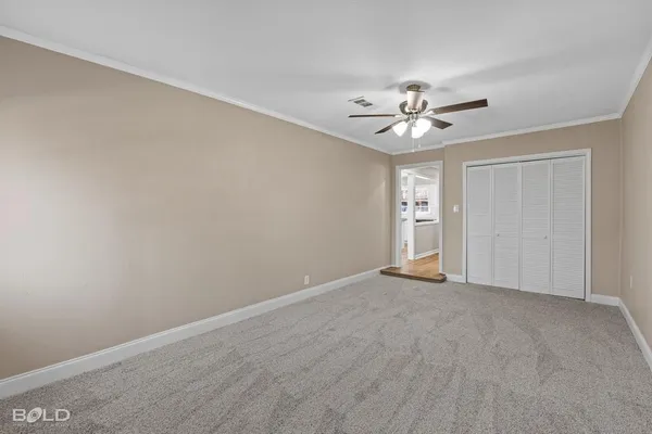 a view of an empty room with a ceiling fan and window
