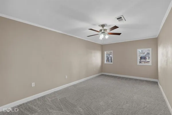 an empty room with windows and ceiling fan