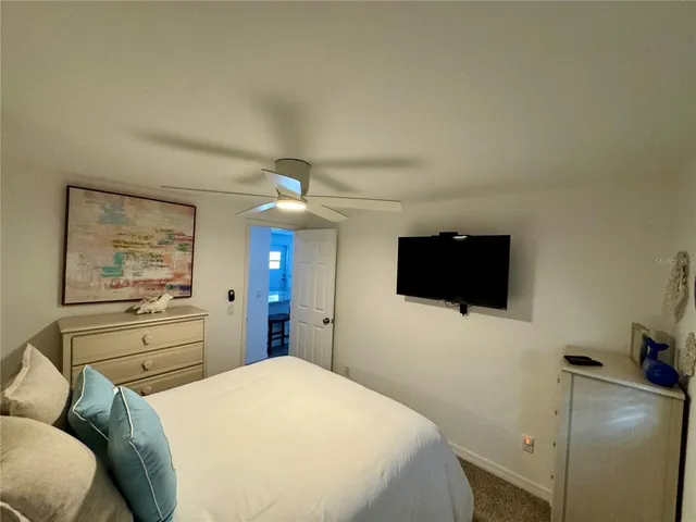 a living room with furniture a flat screen tv and a large window