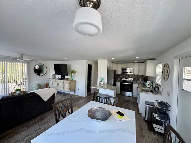 a kitchen with stainless steel appliances granite countertop a sink a stove and a refrigerator