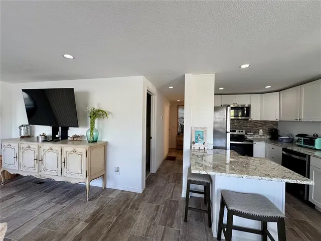 a dining room with furniture and a floor to ceiling window