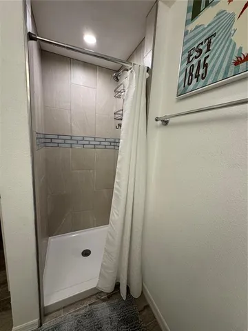 a bedroom with a bed and a flat tv screen on the dresser