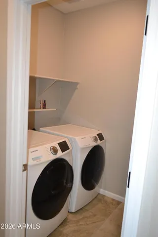 a view of an empty room with a chandelier fan