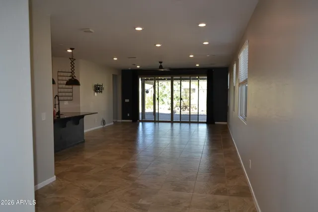 a view of a hallway with wooden floor and windows