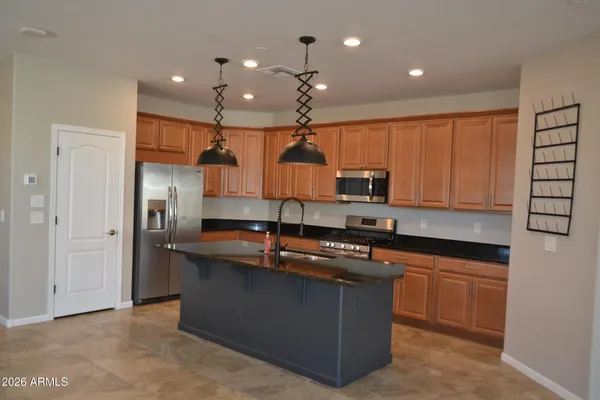 a kitchen with stainless steel appliances granite countertop a sink a stove and a refrigerator