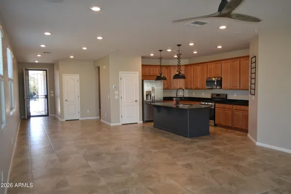 a large kitchen with stainless steel appliances granite countertop a large counter top and a view of living room