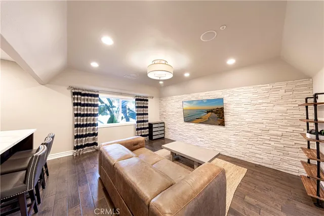 a dining room with wooden floor a chandelier a wooden table and chairs
