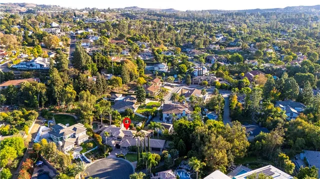 a view of a house with a yard and palm trees