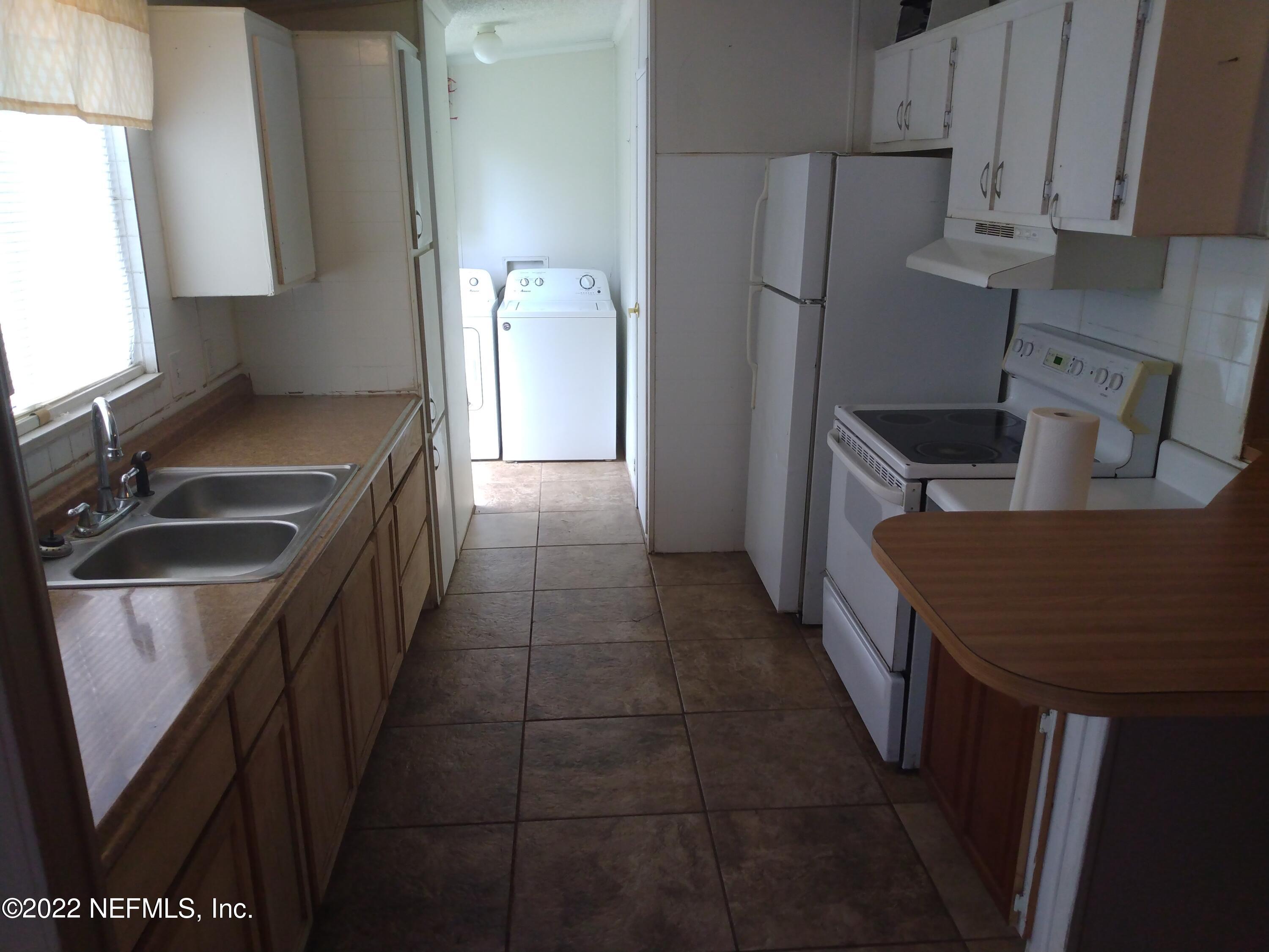 3563 Loango Road Orange Park, FL 32065 - Photo 5 of 6 a kitchen with stainless steel appliances granite countertop a sink stove and refrigerator