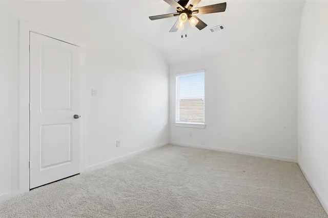 an empty room with a window and a fan