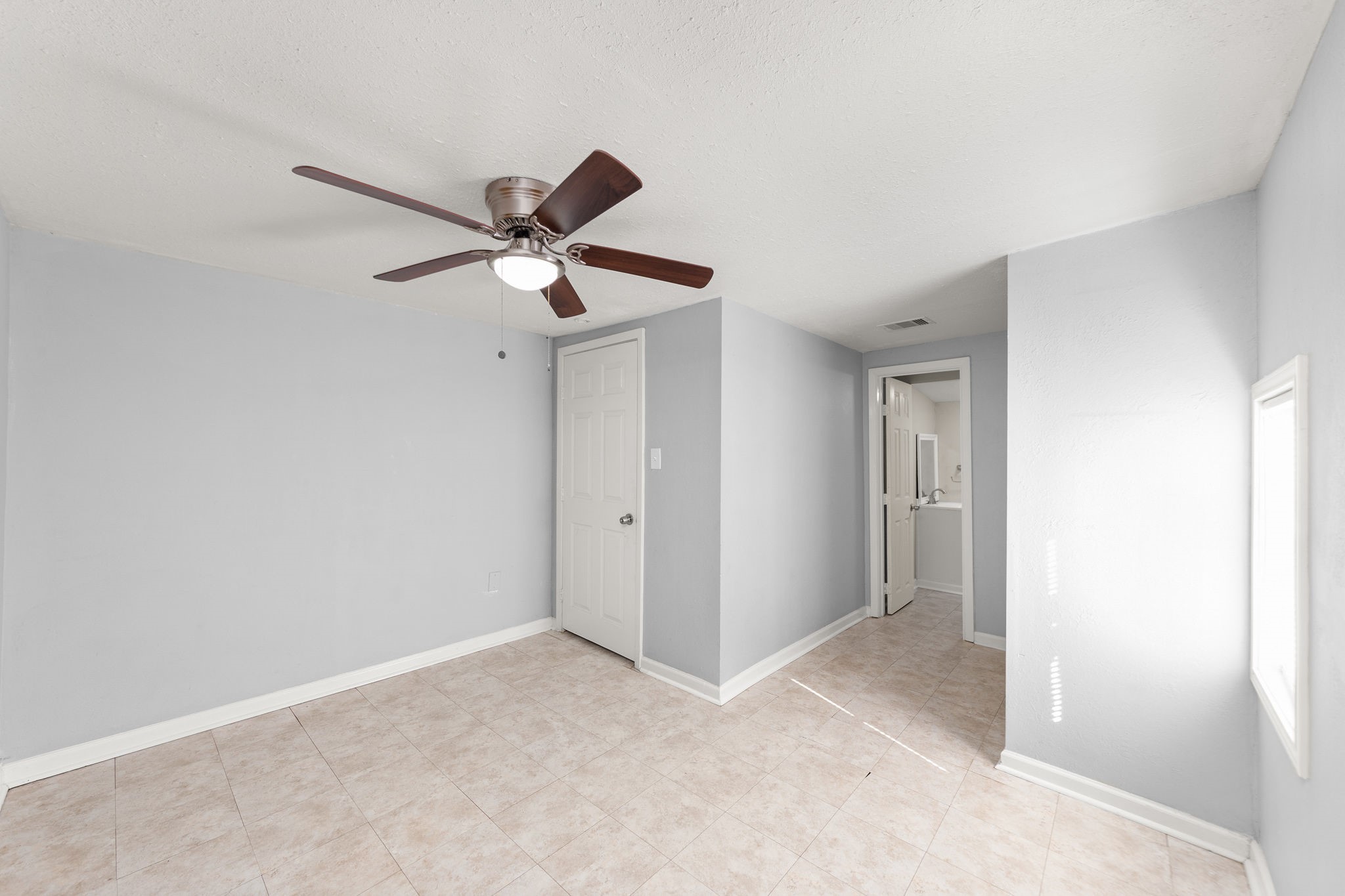 203 South Fig Street Sweeny, TX 77480 - Photo 11 of 20 Bedroom 2- Bright and airy bedroom featuring neutral tones, and easy access to the adjacent bathroom.