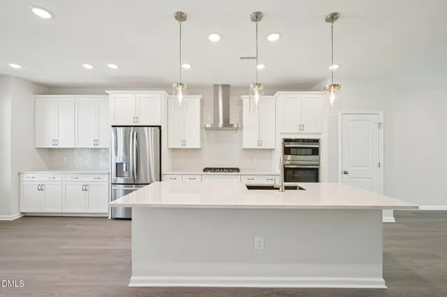 a kitchen with kitchen island white cabinets and stainless steel appliances