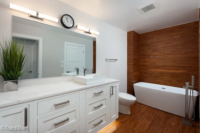 a bathroom with a sink a toilet and a large mirror