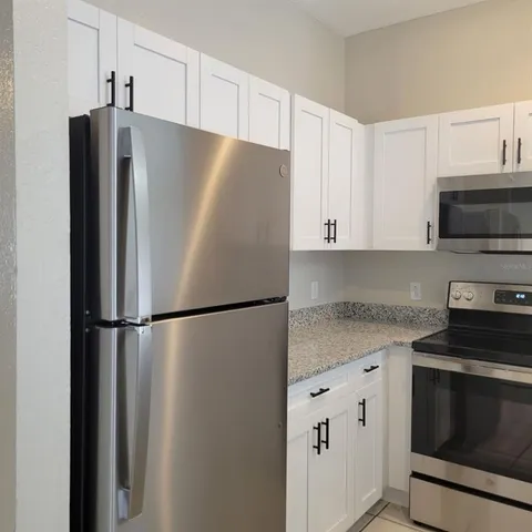 a kitchen with granite countertop a sink and cabinets
