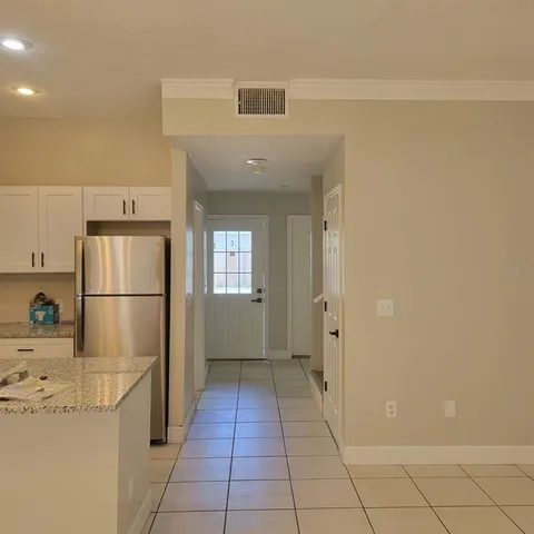 a kitchen with a refrigerator a stove top oven and cabinets
