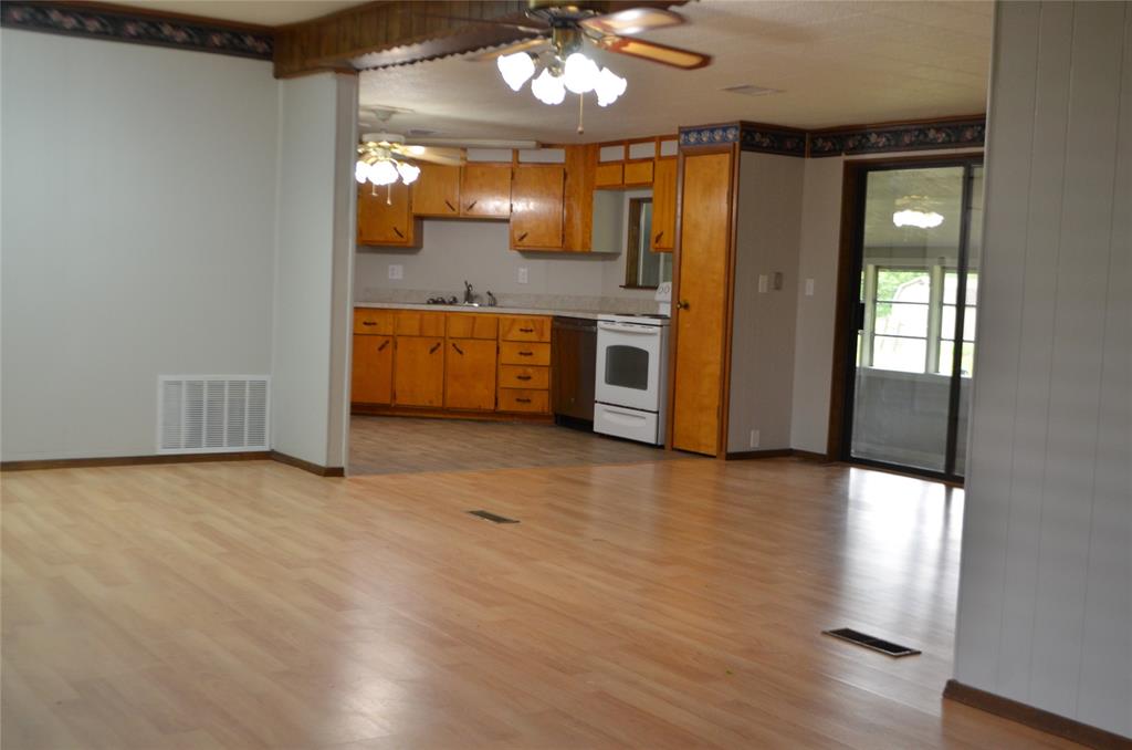2020 Gage Road Cleburne, TX 76031 - Photo 3 of 12 Open-concept living area with wood-finish flooring extending into the kitchen