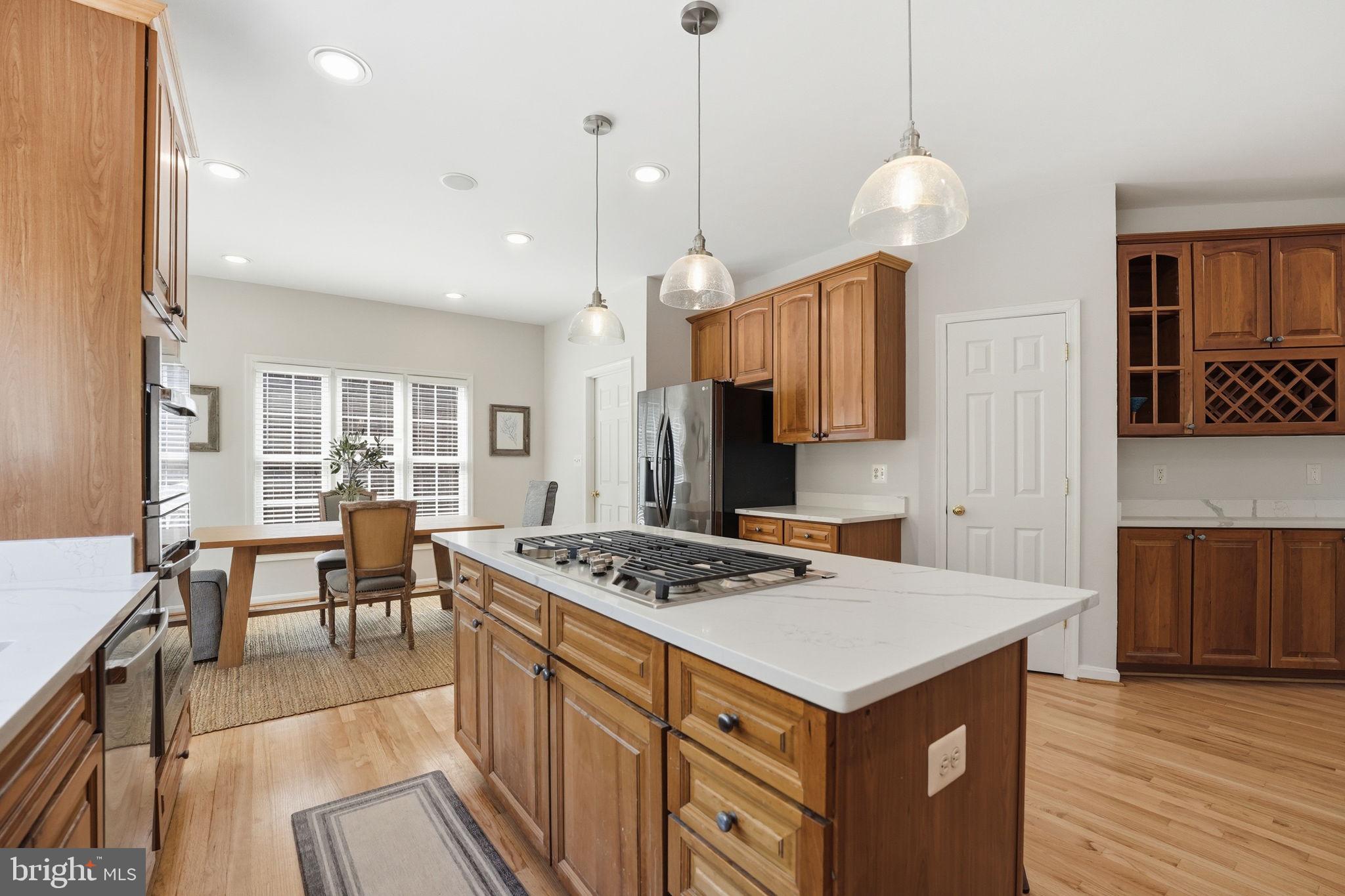6075 Deer Ridge Trail Springfield, VA 22150 - Photo 13 of 61 a kitchen that has a stove a table and chairs in it