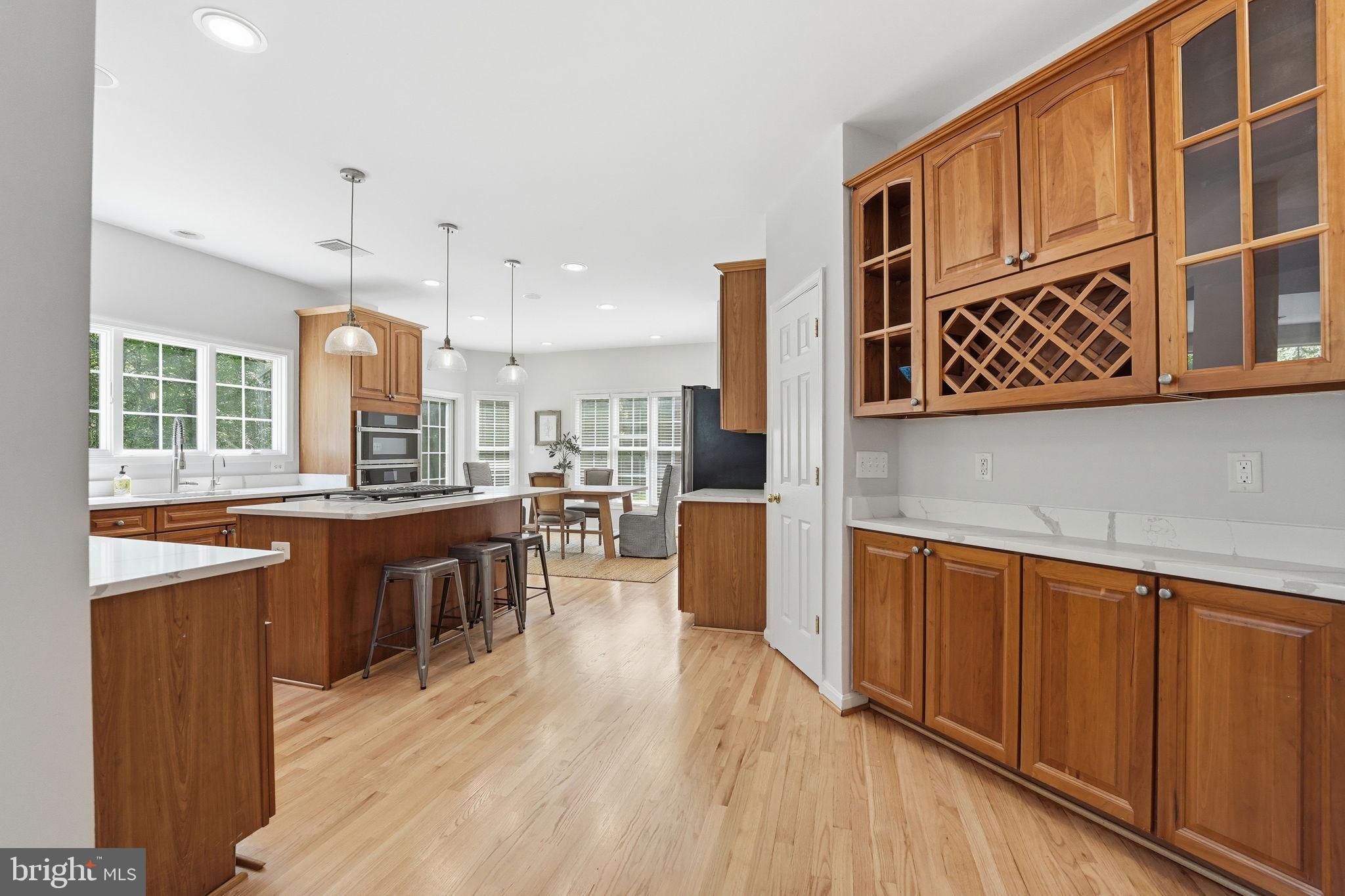 6075 Deer Ridge Trail Springfield, VA 22150 - Photo 10 of 61 a kitchen with stainless steel appliances granite countertop wooden floors wooden cabinets a sink and a dishwasher