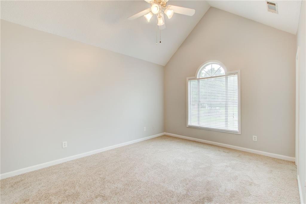 837 Ravins Way Stockbridge, GA 30281 - Photo 12 of 32 an empty room with windows and chandelier fan