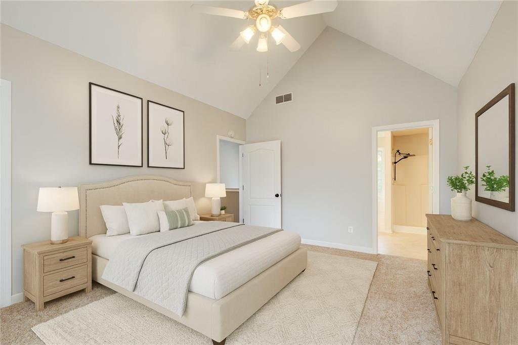 837 Ravins Way Stockbridge, GA 30281 - Photo 13 of 32 a bedroom with a large bed and a chandelier